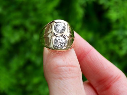 fig 1. A wide 14ct yellow gold ring featuring two round diamonds set vertically within carved linear accents.