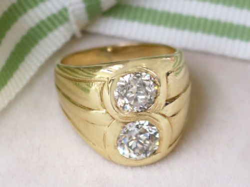 fig 2. A wide 14ct yellow gold ring featuring two round diamonds set vertically within carved linear accents.