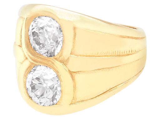 fig 3. A wide 14ct yellow gold ring featuring two round diamonds set vertically within carved linear accents.