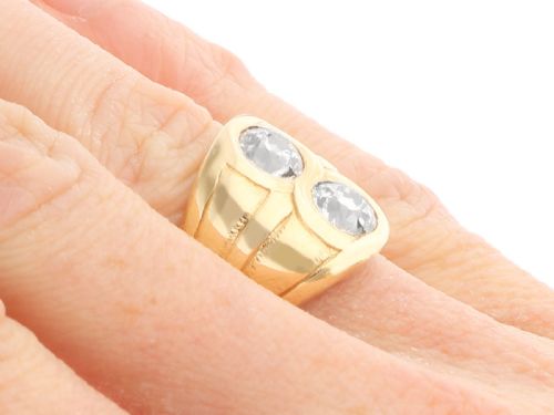 fig 7. A wide 14ct yellow gold ring featuring two round diamonds set vertically within carved linear accents.