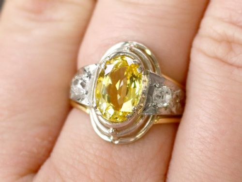 fig 2. An Art Deco 18ct yellow gold and platinum ring featuring a central oval yellow sapphire flanked by single diamonds.