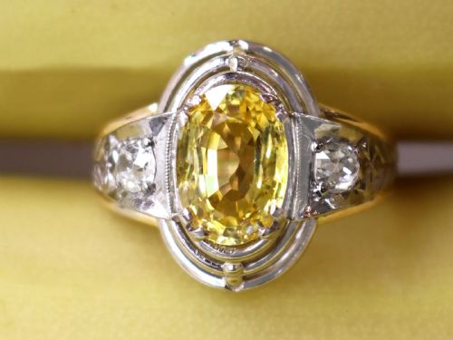 fig 3. An Art Deco 18ct yellow gold and platinum ring featuring a central oval yellow sapphire flanked by single diamonds.