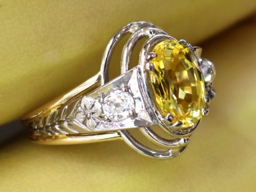fig 4. An Art Deco 18ct yellow gold and platinum ring featuring a central oval yellow sapphire flanked by single diamonds.