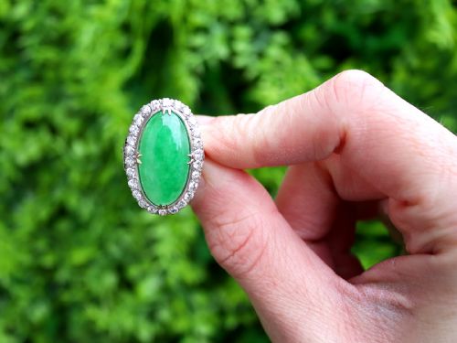 fig 1. An antique Edwardian ring featuring a large oval green jadeite cabochon encircled by a halo of round diamonds on a gold band.