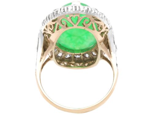 fig 5. An antique Edwardian ring featuring a large oval green jadeite cabochon encircled by a halo of round diamonds on a gold band.