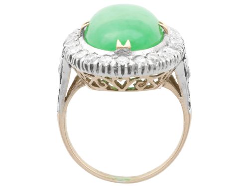 fig 6. An antique Edwardian ring featuring a large oval green jadeite cabochon encircled by a halo of round diamonds on a gold band.