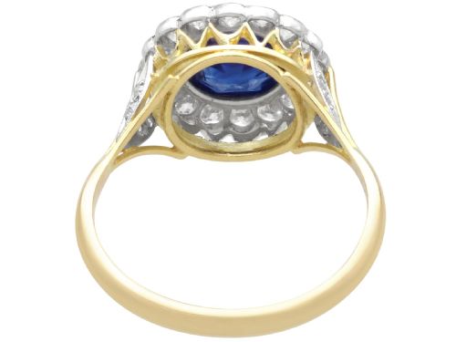 fig 5. An antique 18ct yellow gold ring featuring a central round blue sapphire encircled by a halo of bright diamonds set within a scalloped millegrain bezel.