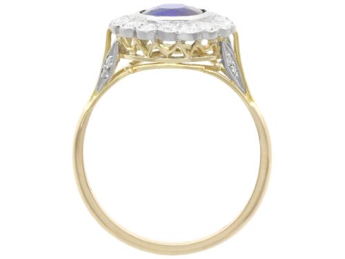 fig 6. An antique 18ct yellow gold ring featuring a central round blue sapphire encircled by a halo of bright diamonds set within a scalloped millegrain bezel.