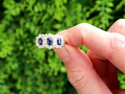 fig 1. An antique 18ct yellow gold ring featuring three rectangular cushion-cut blue sapphires surrounded by a halo of old-cut diamonds.