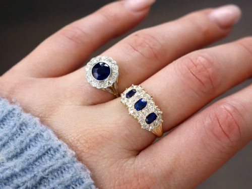 fig 3. An antique 18ct yellow gold ring featuring three rectangular cushion-cut blue sapphires surrounded by a halo of old-cut diamonds.