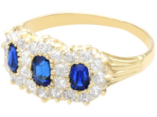 fig 4. An antique 18ct yellow gold ring featuring three rectangular cushion-cut blue sapphires surrounded by a halo of old-cut diamonds.