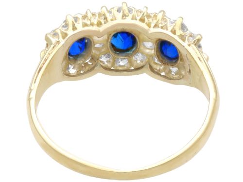 fig 5. An antique 18ct yellow gold ring featuring three rectangular cushion-cut blue sapphires surrounded by a halo of old-cut diamonds.