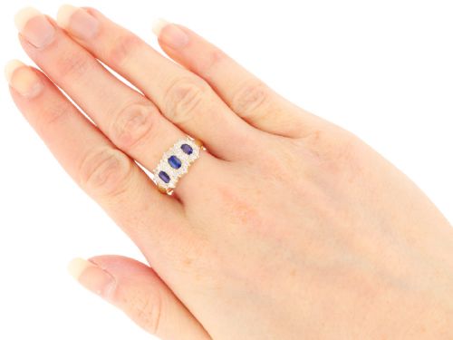 fig 8. An antique 18ct yellow gold ring featuring three rectangular cushion-cut blue sapphires surrounded by a halo of old-cut diamonds.