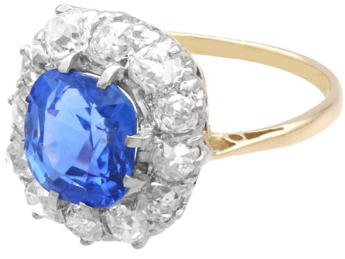 fig 4. An antique Art Deco ring featuring a cushion-cut blue sapphire central stone surrounded by a cluster halo of round diamonds set on a yellow gold band.