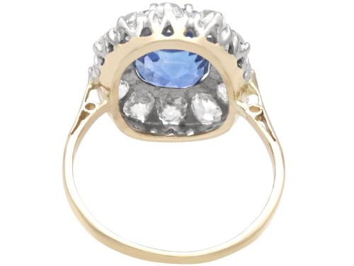 fig 5. An antique Art Deco ring featuring a cushion-cut blue sapphire central stone surrounded by a cluster halo of round diamonds set on a yellow gold band.