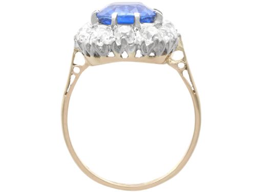 fig 6. An antique Art Deco ring featuring a cushion-cut blue sapphire central stone surrounded by a cluster halo of round diamonds set on a yellow gold band.
