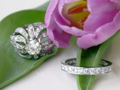 fig 2. A platinum dress ring featuring a central round brilliant cut diamond surrounded by openwork diamond-set petal motifs.