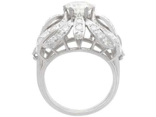 fig 6. A platinum dress ring featuring a central round brilliant cut diamond surrounded by openwork diamond-set petal motifs.