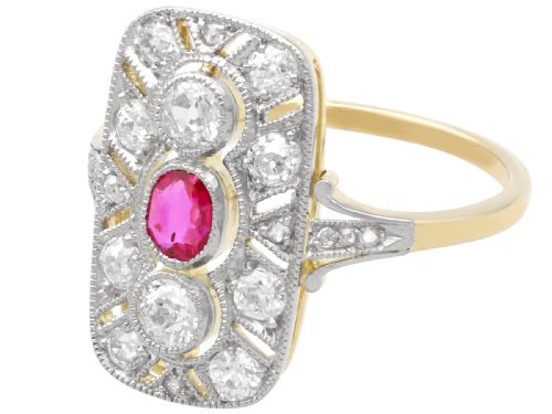 fig 4. An Art Deco 14ct yellow gold dress ring featuring a central oval red ruby set within a rectangular pierced openwork plaque adorned with round diamonds and millegrain edging.