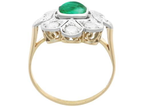 fig 6. An Art Deco dress ring featuring a central cushion-cut green emerald surrounded by a geometric pierced diamond halo set in white metal on an 18ct yellow gold band.