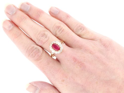 fig 7. An 18ct yellow gold ring featuring a central oval faceted ruby surrounded by a halo of twelve old cut diamonds in claw settings.