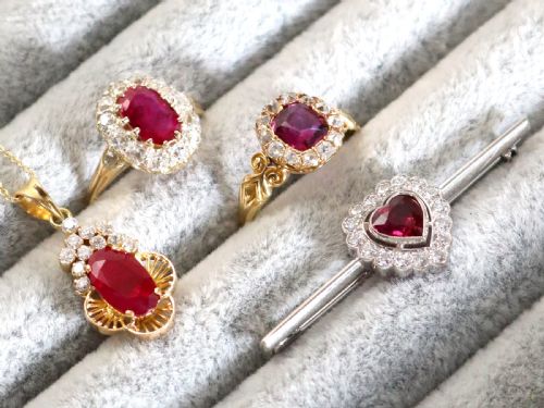 fig 2. A vintage 18k white gold bar brooch featuring a central heart-cut red ruby framed by a diamond halo, mounted on a slender polished bar.