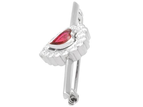fig 3. A vintage 18k white gold bar brooch featuring a central heart-cut red ruby framed by a diamond halo, mounted on a slender polished bar.