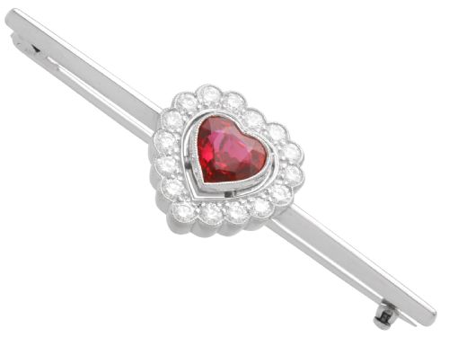 fig 4. A vintage 18k white gold bar brooch featuring a central heart-cut red ruby framed by a diamond halo, mounted on a slender polished bar.