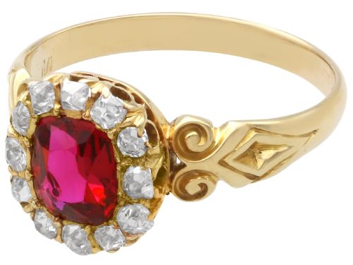 fig 4. An 18ct yellow gold Victorian cluster ring featuring a central cushion-cut red ruby framed by twelve hand-cut diamonds with carved scroll shoulders.