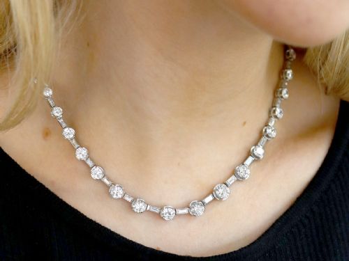 fig 2. An antique Art Deco platinum necklace set with alternating round cut and baguette cut diamonds linked in a continuous line.