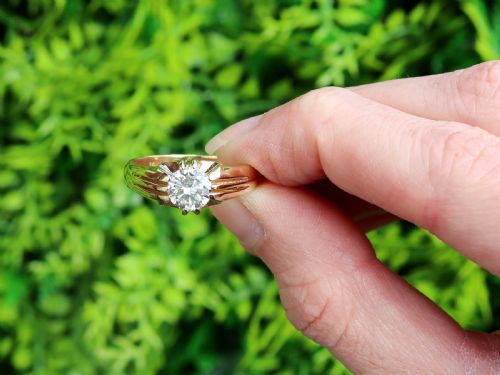 fig 1. An 18ct yellow gold solitaire ring featuring a round central diamond held in a claw setting with fluted shoulders.