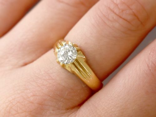 fig 3. An 18ct yellow gold solitaire ring featuring a round central diamond held in a claw setting with fluted shoulders.