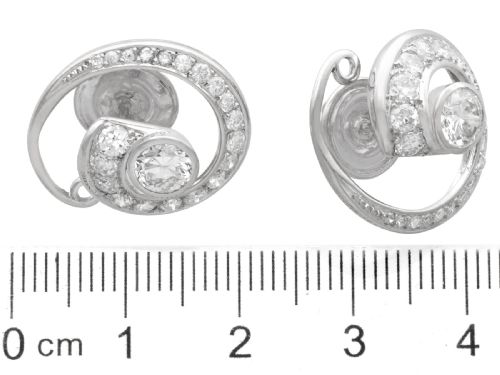 fig 7. A pair of 14ct white gold twirl earrings featuring round brilliant cut diamonds set in a concentric spiral design around a central diamond.