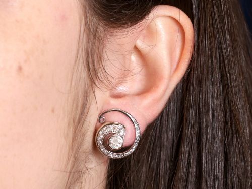 fig 8. A pair of 14ct white gold twirl earrings featuring round brilliant cut diamonds set in a concentric spiral design around a central diamond.