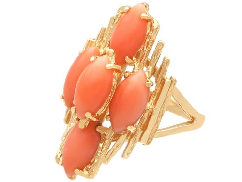 fig 5. A 1960s 14ct yellow gold cocktail ring featuring five marquise cabochon corals set within a textured abstract gold framework.