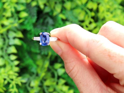 fig 1. An Art Deco platinum ring featuring a central cushion-cut blue sapphire flanked by a stepped baguette-cut diamond on each shoulder.