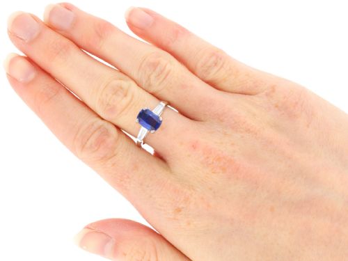fig 8. An Art Deco platinum ring featuring a central cushion-cut blue sapphire flanked by a stepped baguette-cut diamond on each shoulder.