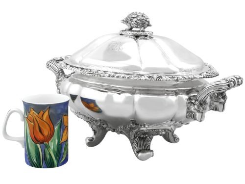 fig 3. An antique silver soup tureen featuring a lobed body, scrolled acanthus feet, double side handles, and a domed lid topped with an animal finial.