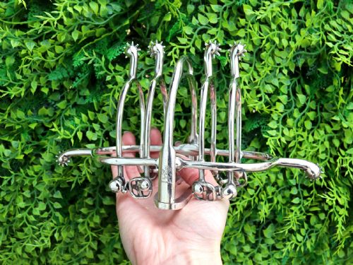 fig 1. An antique sterling silver toast rack designed with equestrian riding spurs and rowels.