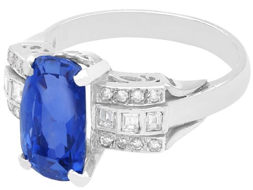 fig 3. An Art Deco platinum cocktail ring featuring a large cushion-cut blue Ceylon sapphire held in four prongs between geometric diamond-set shoulders.
