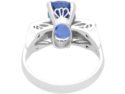 fig 4. An Art Deco platinum cocktail ring featuring a large cushion-cut blue Ceylon sapphire held in four prongs between geometric diamond-set shoulders.