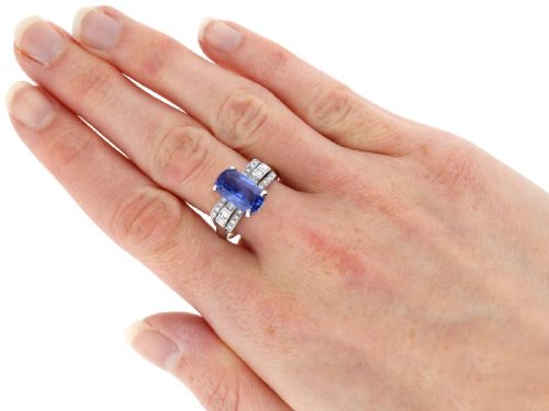 fig 7. An Art Deco platinum cocktail ring featuring a large cushion-cut blue Ceylon sapphire held in four prongs between geometric diamond-set shoulders.