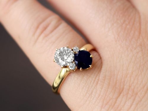 fig 2. An antique 14ct yellow gold ring featuring an oval blue sapphire paired with a round diamond and small accent stones in claw settings.