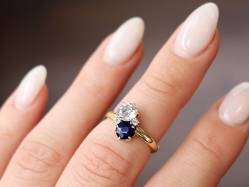 fig 3. An antique 14ct yellow gold ring featuring an oval blue sapphire paired with a round diamond and small accent stones in claw settings.