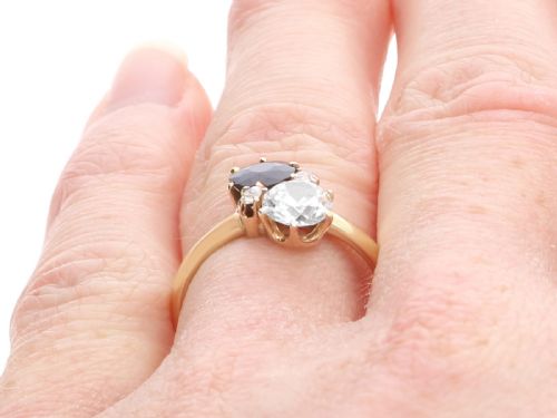 fig 9. An antique 14ct yellow gold ring featuring an oval blue sapphire paired with a round diamond and small accent stones in claw settings.