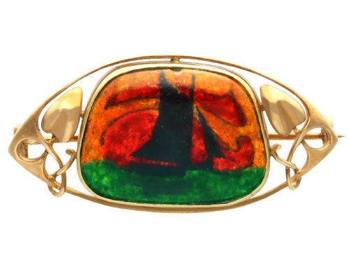 fig 6. An Arts and Crafts 15ct yellow gold brooch featuring a central enamel panel depicting a sailboat against a sunset sky framed by stylized gold leaves.