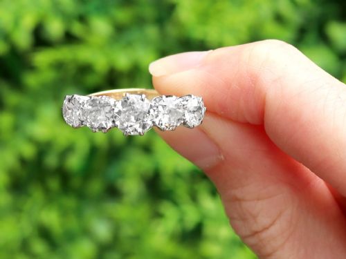 fig 1. An 18ct yellow gold and platinum ring featuring five claw-set round diamonds arranged horizontally in a row.