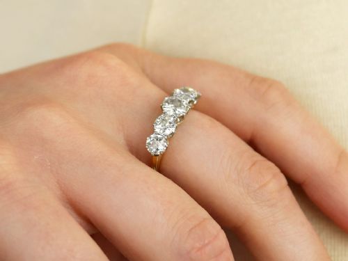 fig 2. An 18ct yellow gold and platinum ring featuring five claw-set round diamonds arranged horizontally in a row.
