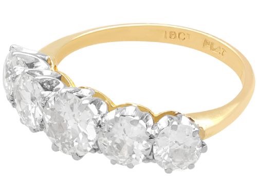 fig 4. An 18ct yellow gold and platinum ring featuring five claw-set round diamonds arranged horizontally in a row.