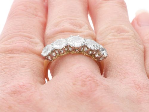 fig 9. An 18ct yellow gold and platinum ring featuring five claw-set round diamonds arranged horizontally in a row.